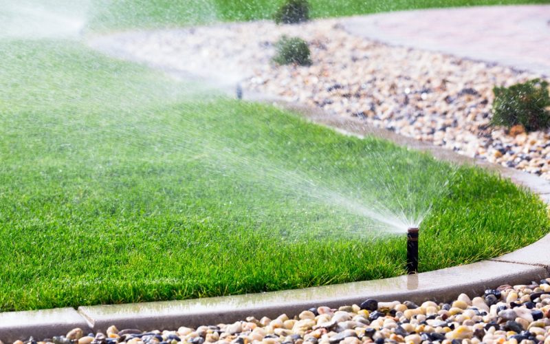 Set of automatic sprinklers watering fresh grass Set of automatic sprinklers watering fresh grass